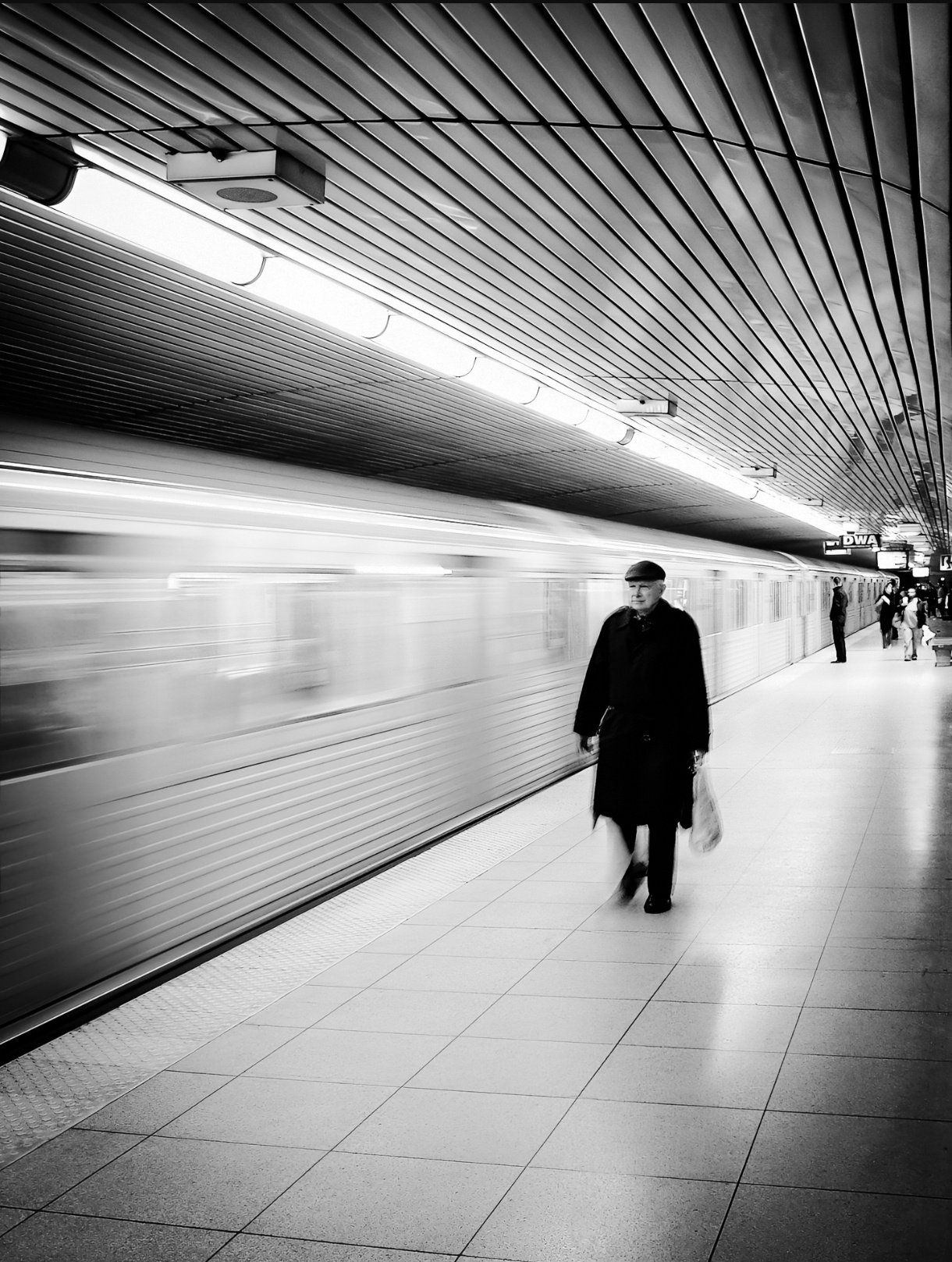 Motion blur of a departing subway train next to a man at Dundas station, Toronto