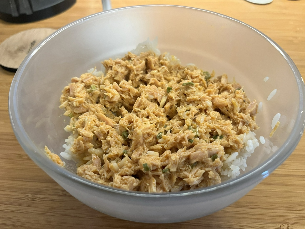 spicy tuna on rice, in a frosted-glass bowl, on a desk