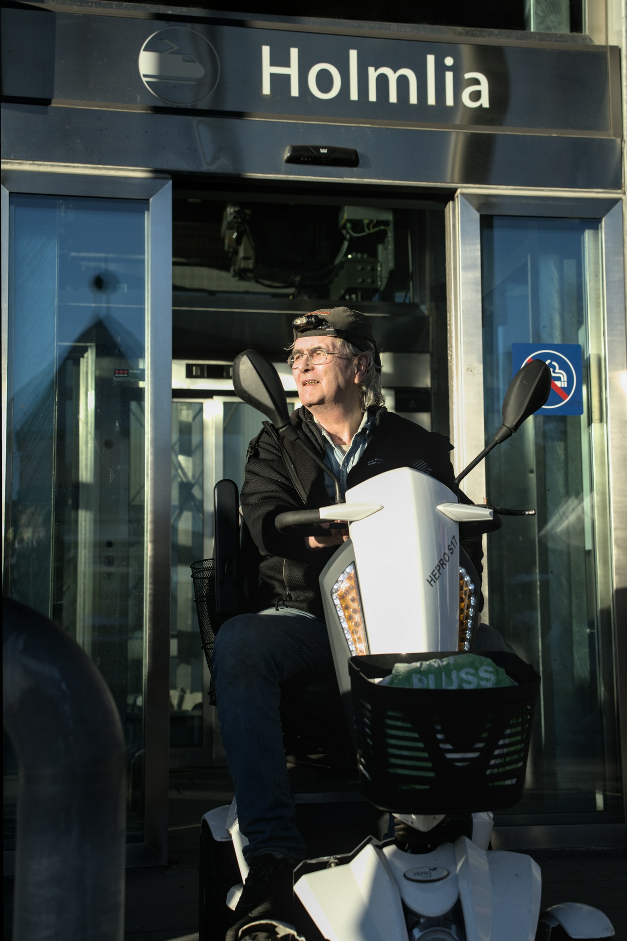 En mann i rullestol foran Holmlia stasjon