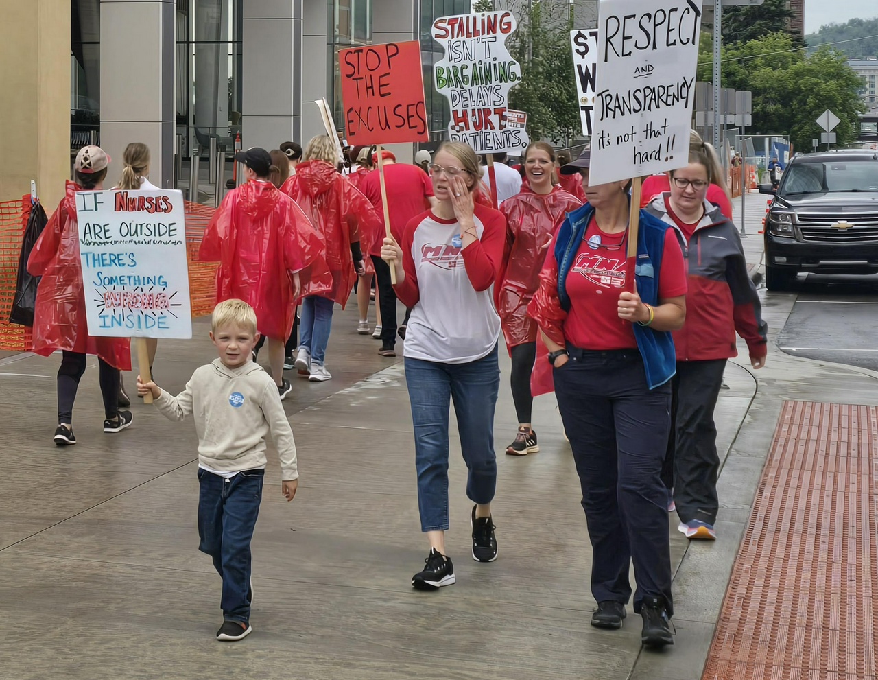 A group of workers on strike carrying picket signs.