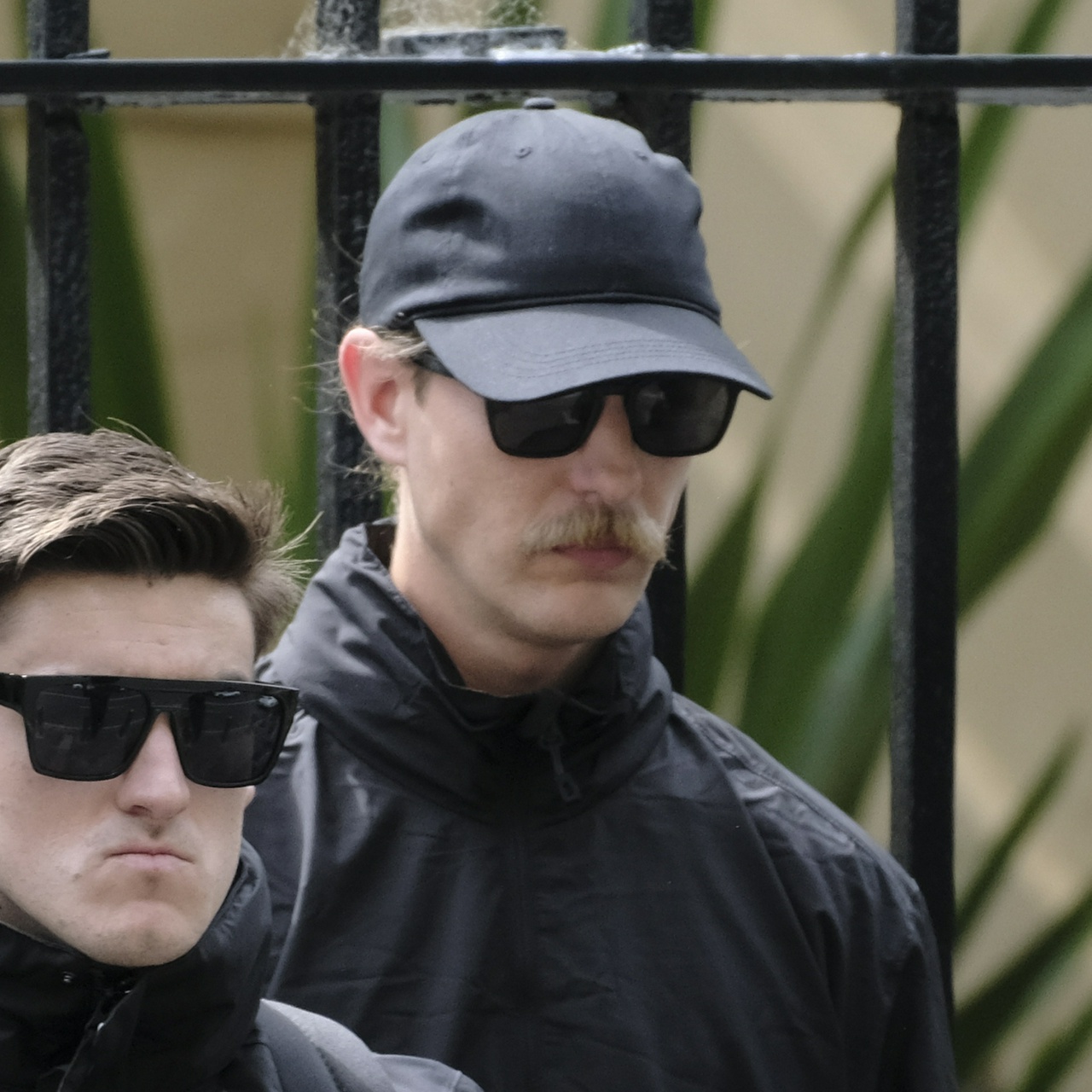 Another man with a walrus moustache, this one tall and blonde and trying to hide longer hair under his cap