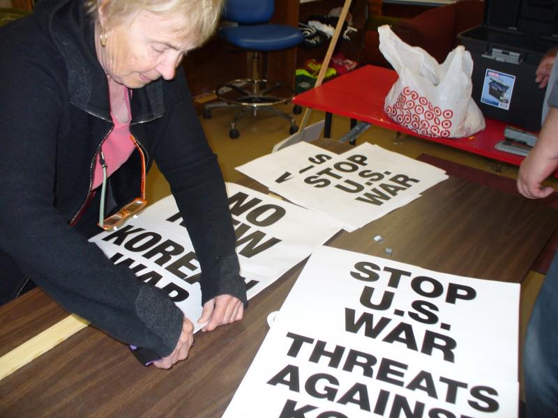 Making signs for April 10 action opposing war with the People's Democratic Repub