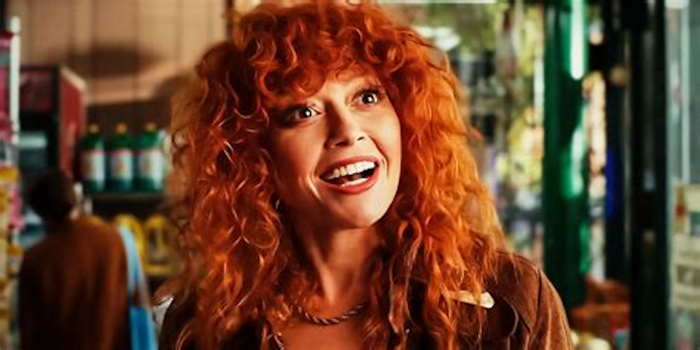 a woman with bright red wolf cut, smiling goofily