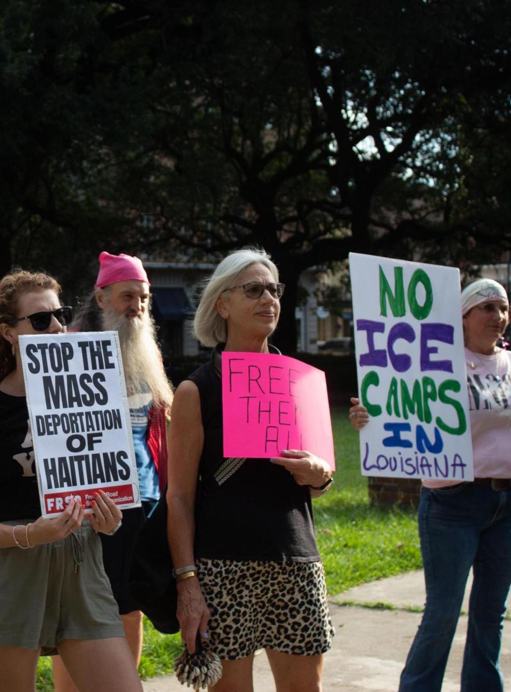Anti-ICE protesters hold signs in Lafayette Square in New Orleans Central Business District. | Fight Back! News