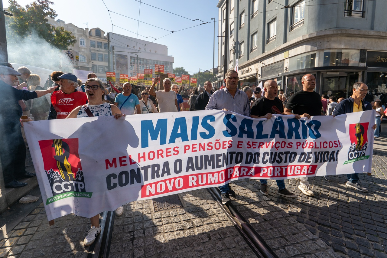 Protesters marching in a street with a banner.
