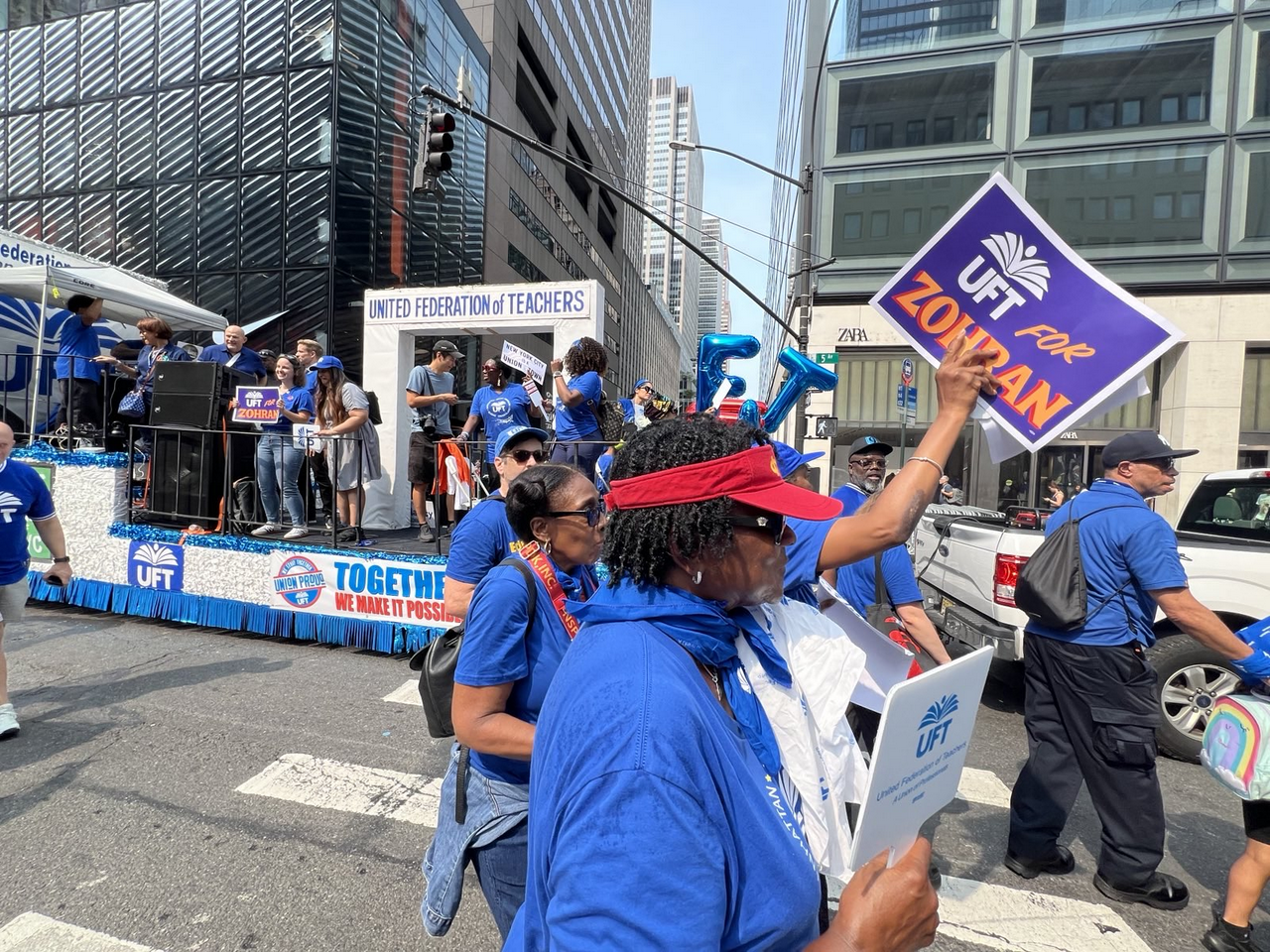 Union members wearing their union T-shirts hold signs that say, 