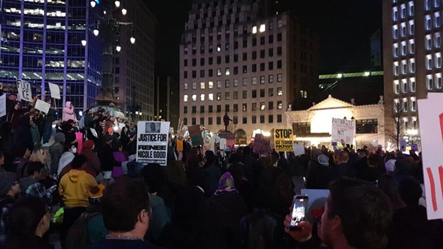 Protestors gathered on monument circle listen intently to the rally speaker.