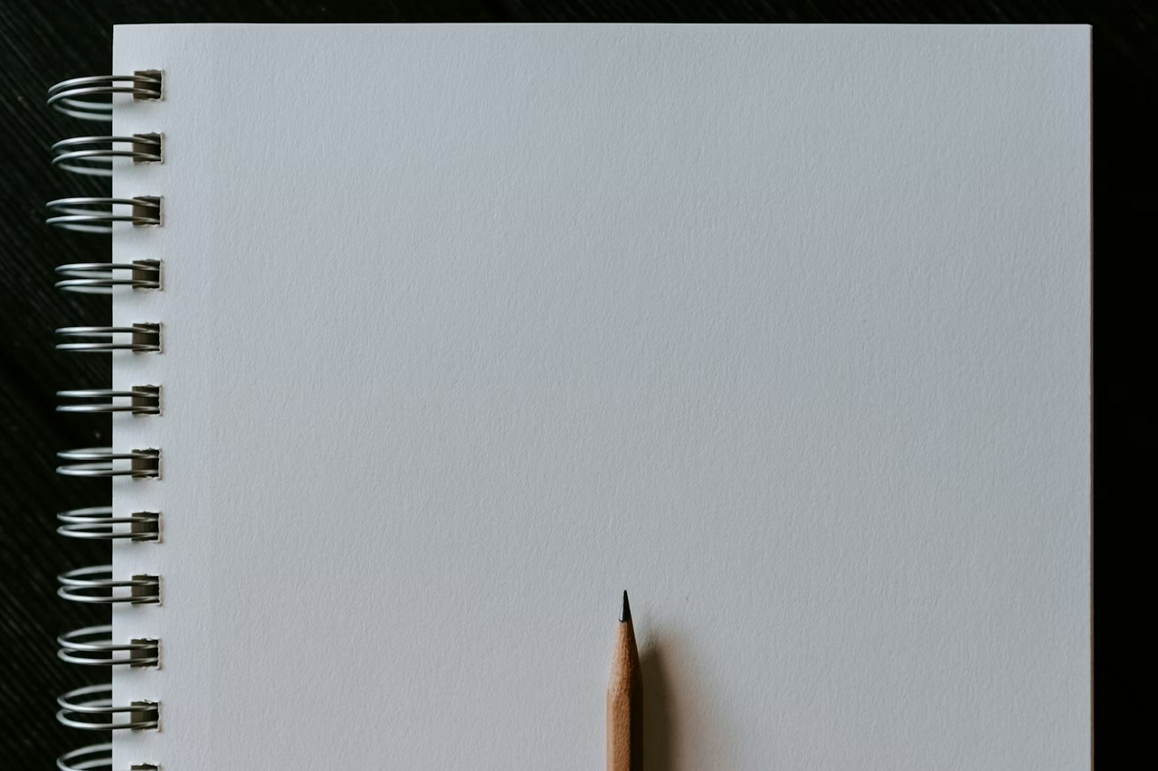 Wooden pencil on blank spiral notebook by Kelly Sikkema for Unsplash