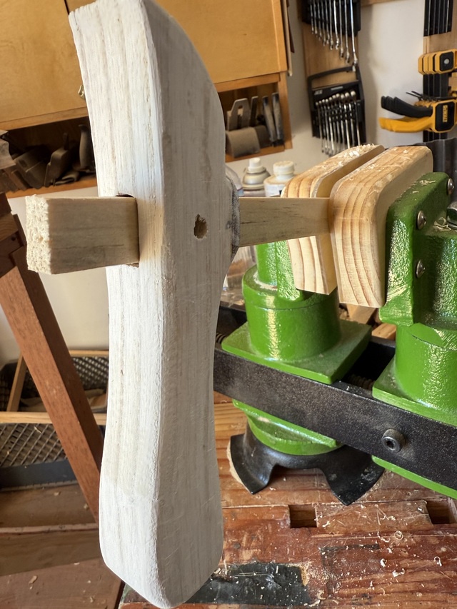 The cane handle on the scrap of wood I previously used to check the mortise, held in the carving vise, after grain-filling with white wood filler