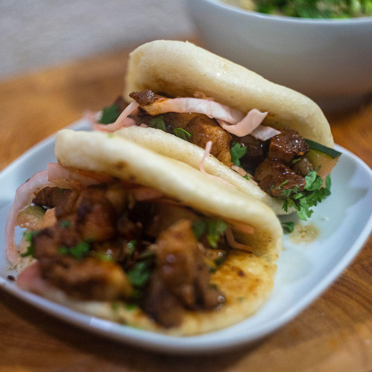 a bao bun filled with pork and pickled cucumber.