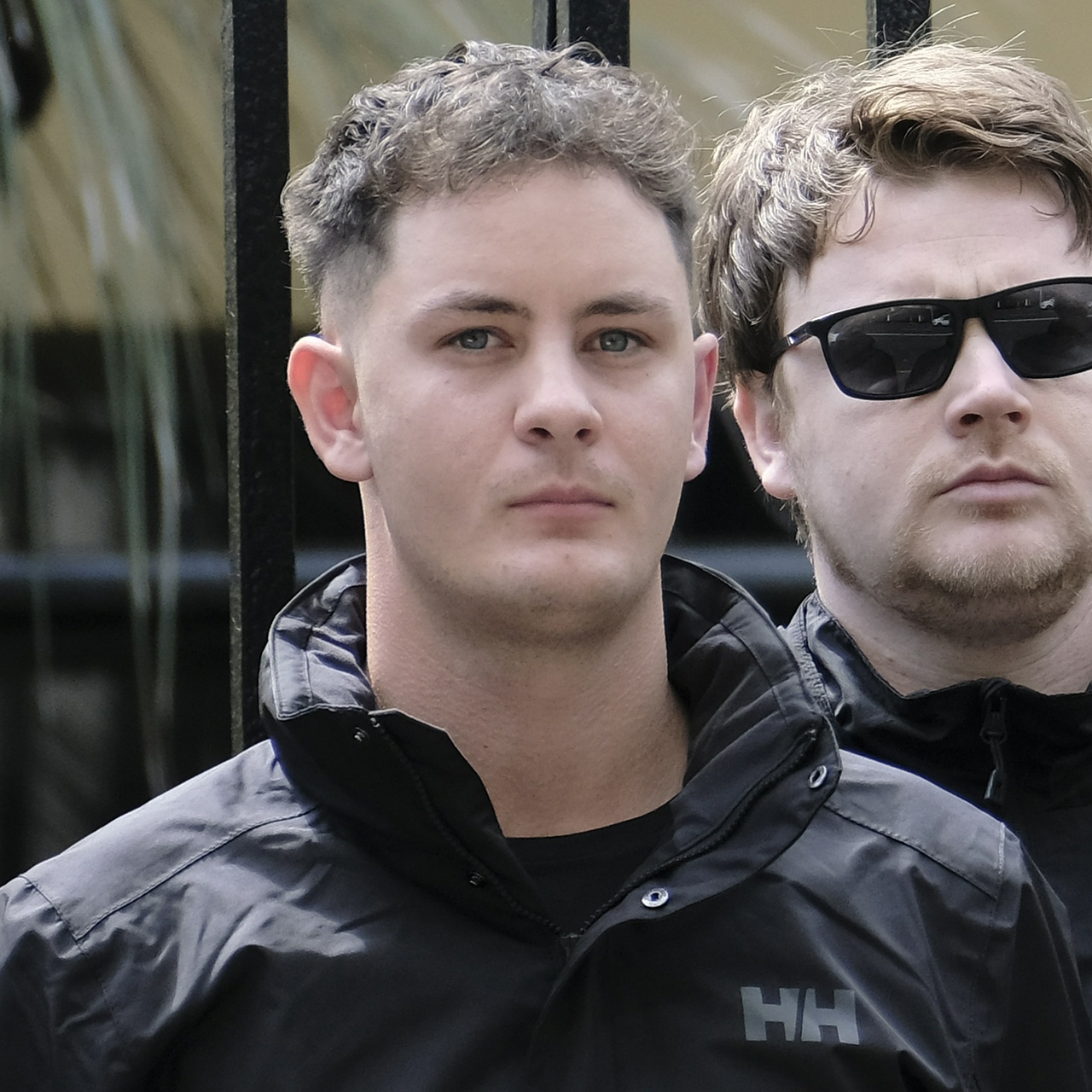 A young man with curly hair, a small mouth and vanishing eyebrows stares down the lens uncertainly