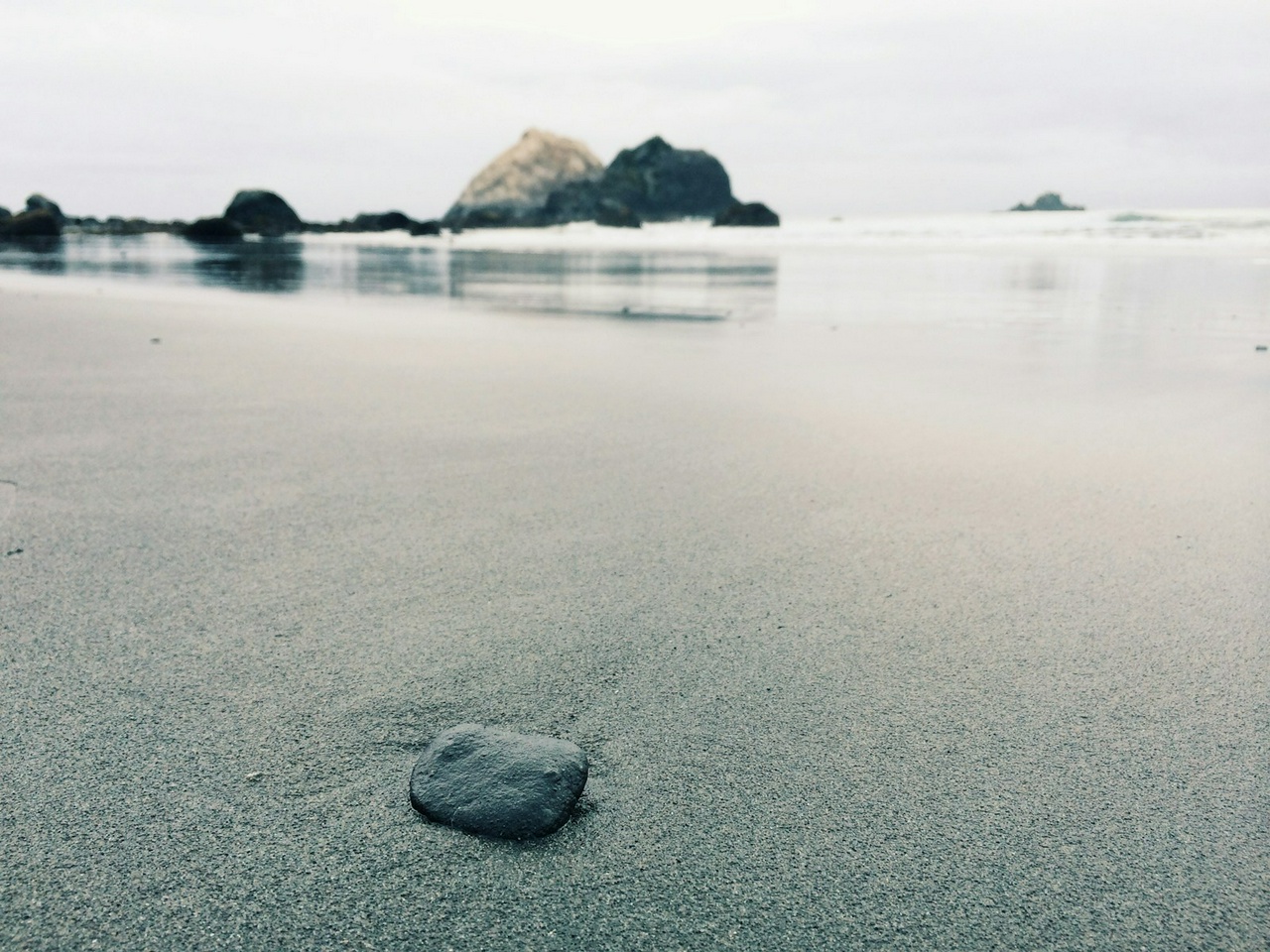 A pebble on a sandy beach.