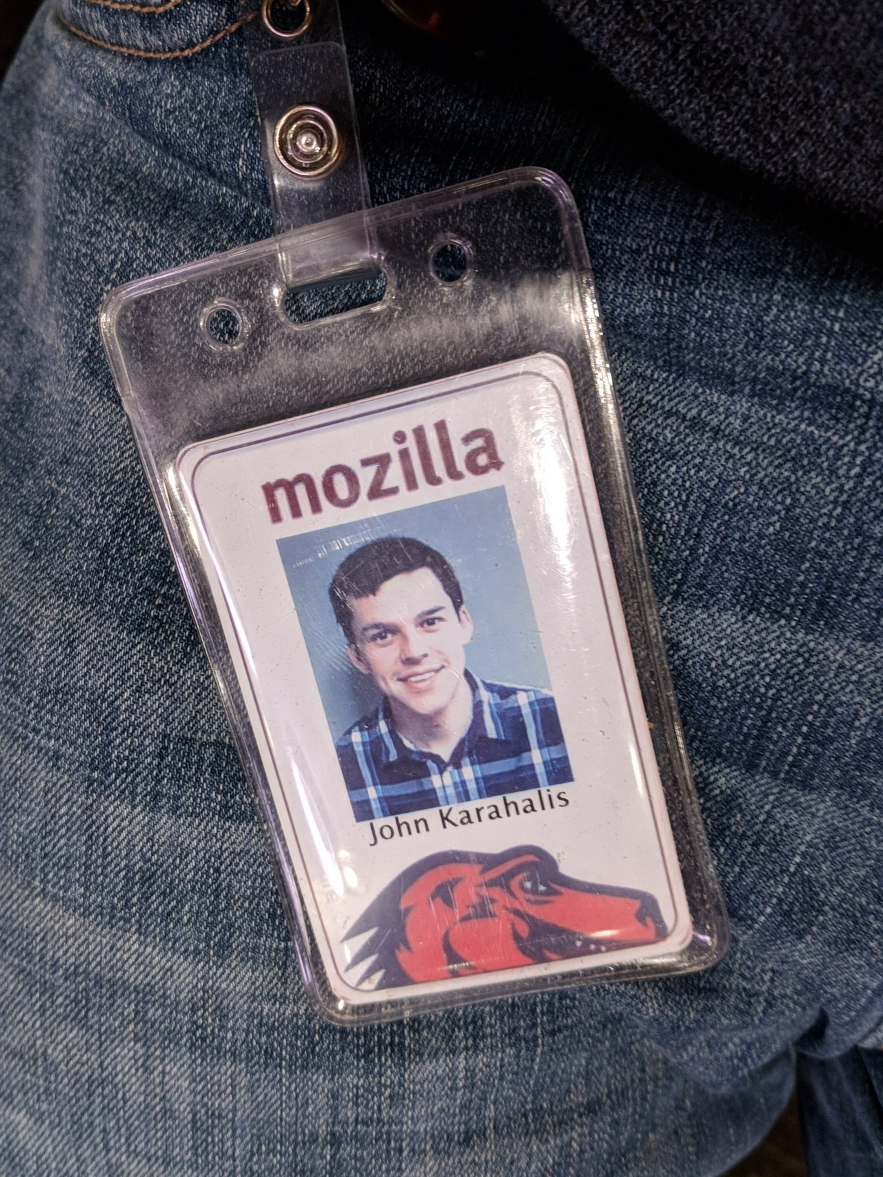 My employee badge resting against my jeans, with my name and photograph shown