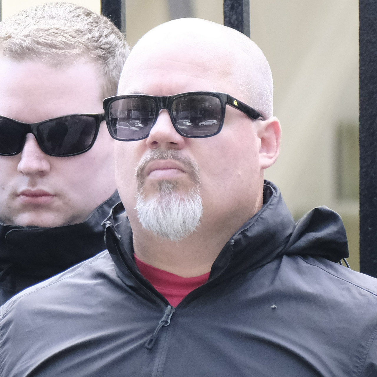 The same man looking worriedly at the camera and sneering, showing how round his face is