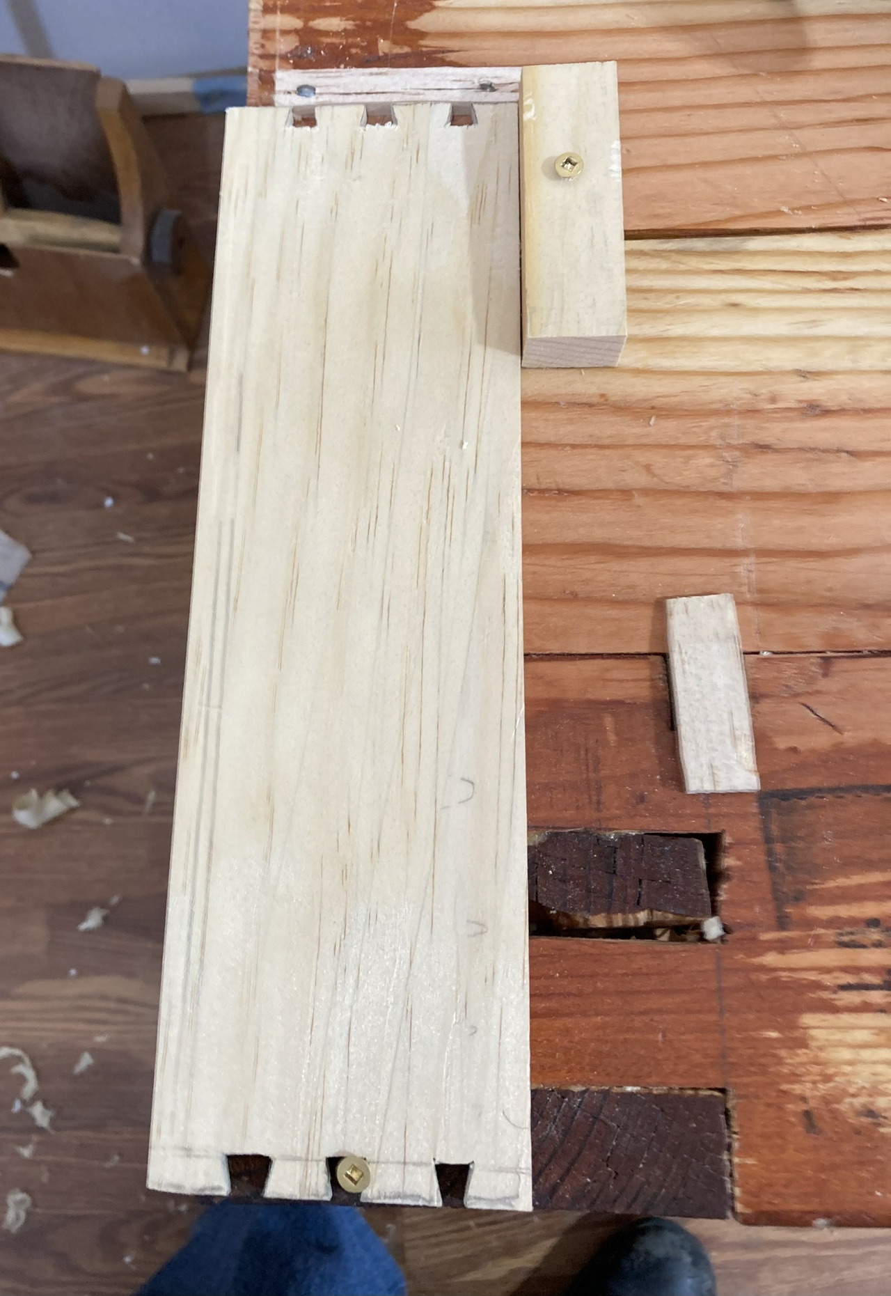 Board held down to the work bench with two screws and a couple boards, in preparation for cutting the groove with a plough plane